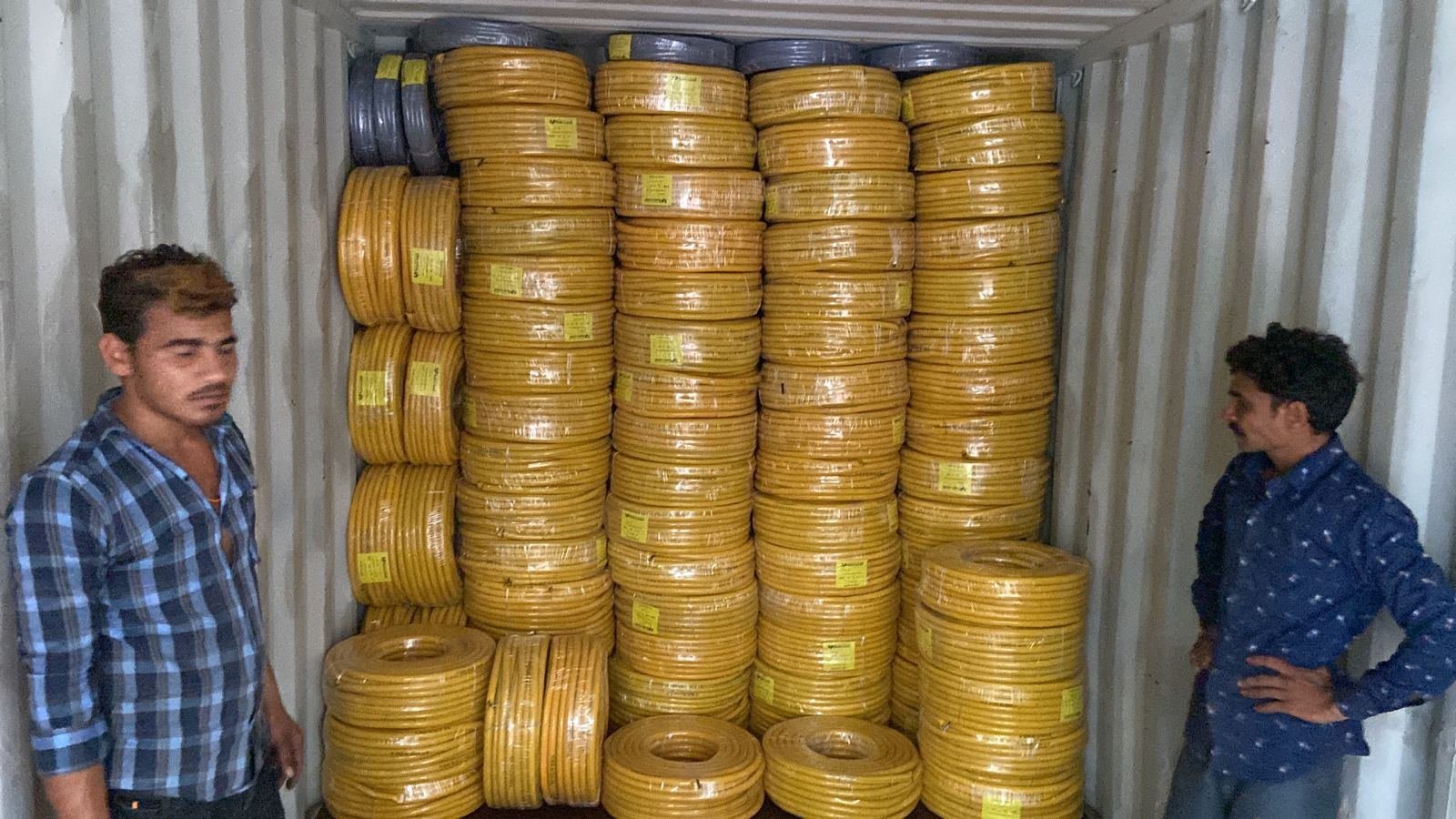 Reinforced PVC hose coils loaded into a container
