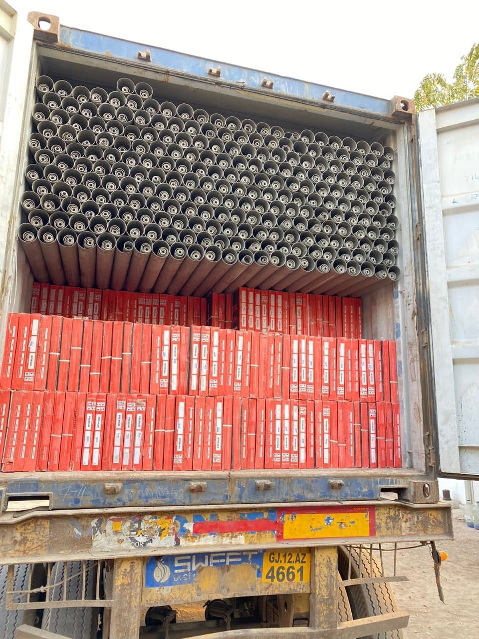 Grey PVC pipe bundles with cartons in a container